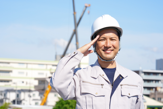 敬礼をする工事現場の男性作業員