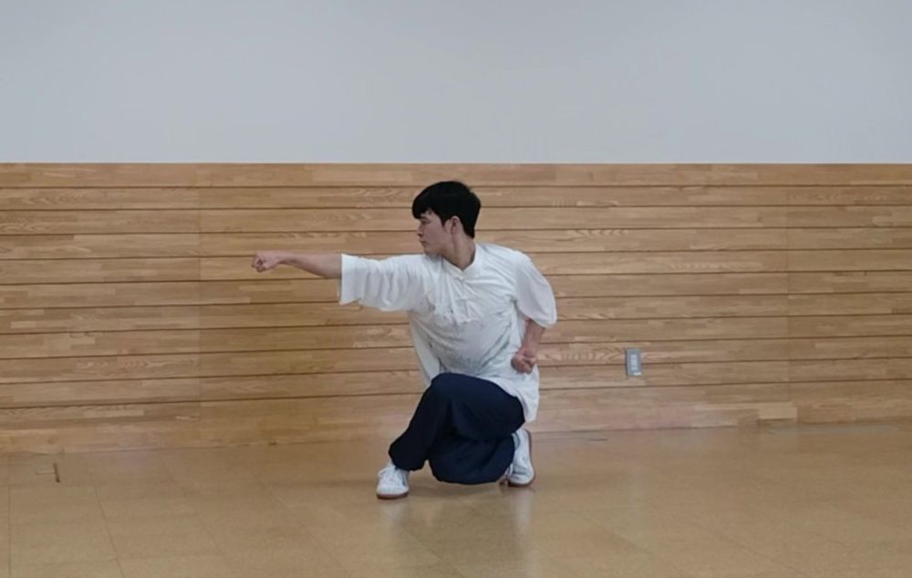 坐って右手を打っている