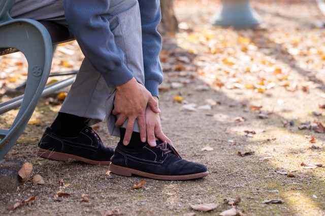 足首をさする中高年の写真