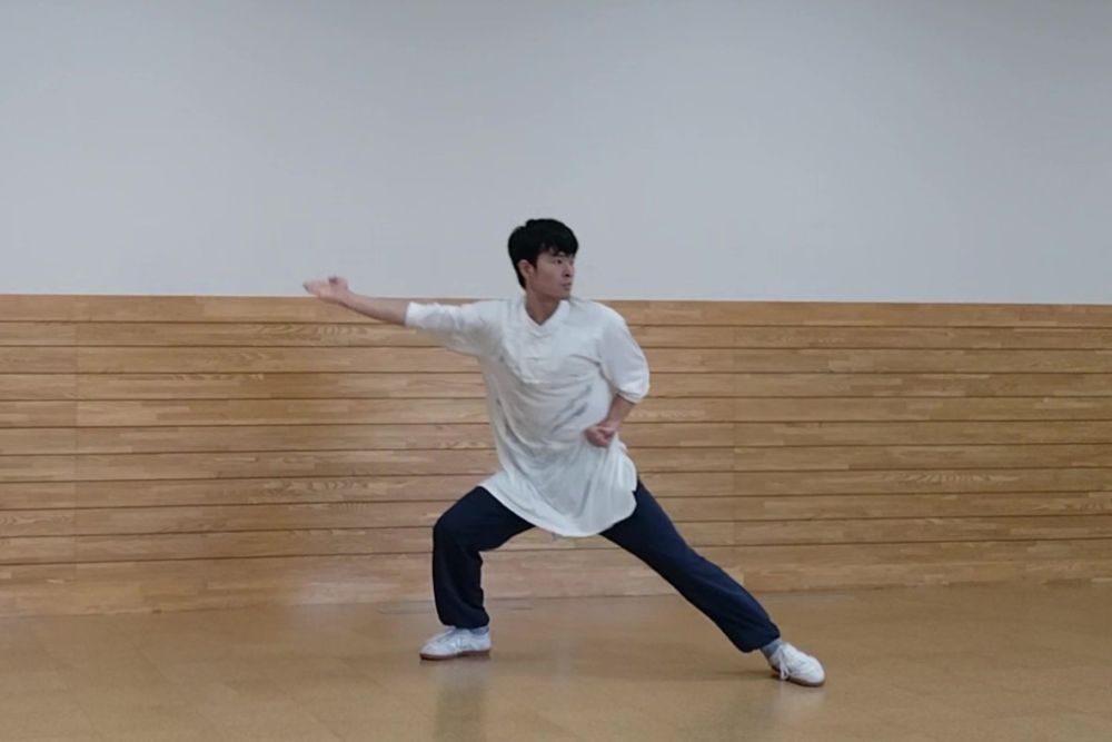 右手を挙げてチョップの構えをしている