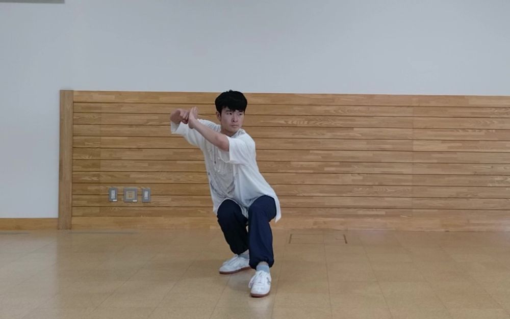 低い片足立ちの姿勢で構えている