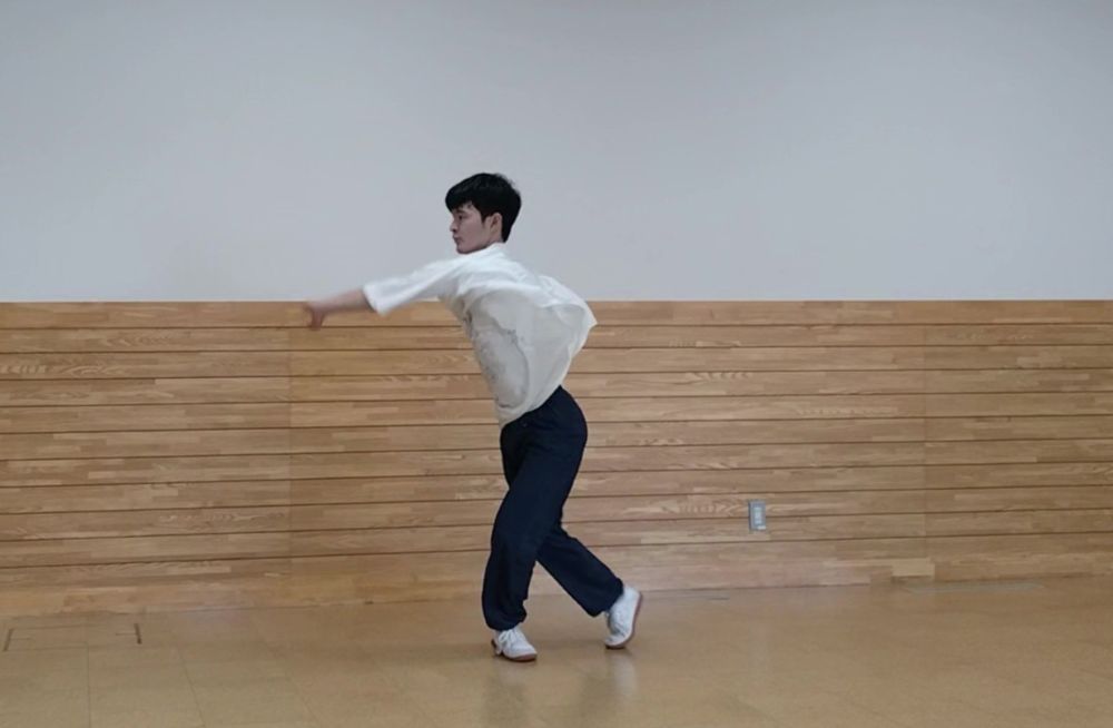 振り返って左手で押さえている