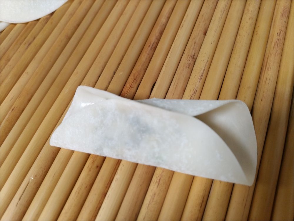 餃子の包みかけ。上下だけがくっついた皮。