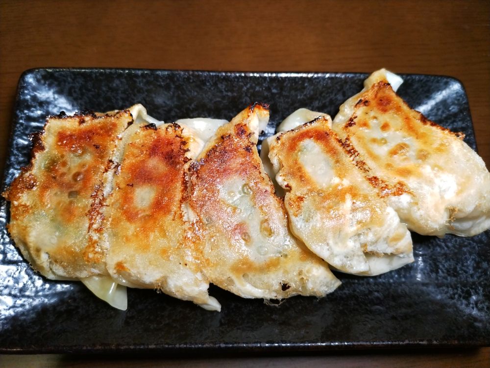 皿の上の焼き餃子。飴色でおいしそう。