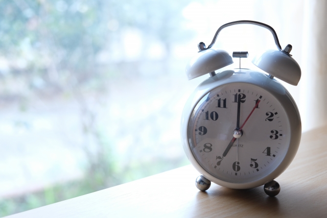 朝七時をさすアナログの目覚まし時計